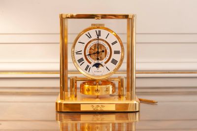 a gold clock sitting on top of a glass table