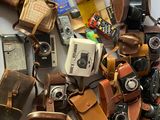 une pile de vieux appareils photo et d'autres objets posés sur une table