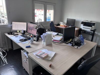 un bureau sur lequel se trouvent deux ordinateurs et une imprimante