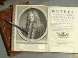 un vieux livre posé sur une table, avec un stylo dessus
