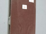 a brown book on a white wall with a sticker on it