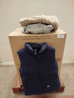 un tas de vêtements posé sur une palette à côté d'un carton