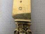 a gold knife with a face on it on a table