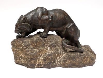bronze statue of a panther on a rock on a white background