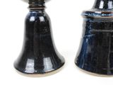 pair of black ceramic salt and pepper shakers on a white background