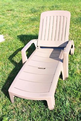 une chaise de jardin posée dans l'herbe