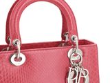 the pink handbag has a silver charm on the handle