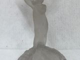 a glass figurine that is on a stand on a table
