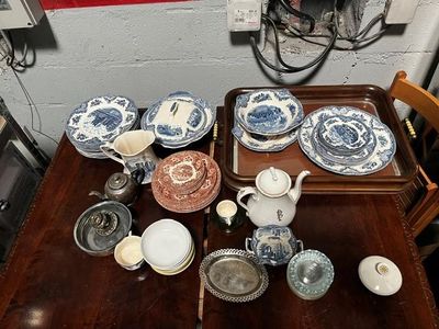 une table en bois sur laquelle se trouve un plateau avec des assiettes et des bols