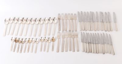 de nombreuses fourchettes et cuillères disposées sur la table
