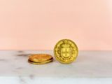 two gold coins sitting on top of a marble counter top