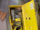une boîte jaune posée par terre, contenant des outils