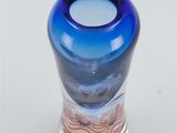 a blue glass vase with a wavy design on it