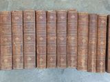 six vieux livres alignés en rangées sur une surface en béton