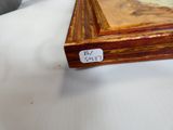 une photo d'un tableau posé sur une table, sur laquelle est posée une étiquette avec un nom