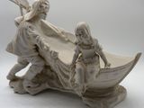 a figurine of a man and a woman in a boat