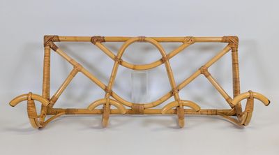 a wicker magazine rack with a glass holder on it