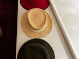 several hats are lined up on a table with a bow tie