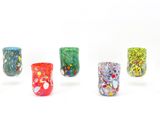 six vases en verre de couleurs différentes posés sur une surface blanche