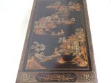 a black and gold table with oriental designs on it