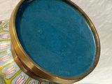 un vase avec un couvercle bleu posé sur une table