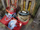 a red cart with a hose and a red fire hydrant