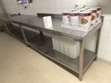 une table en acier inoxydable sur laquelle sont disposés tout un tas de plats