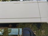 a white van that is parked in front of some trees