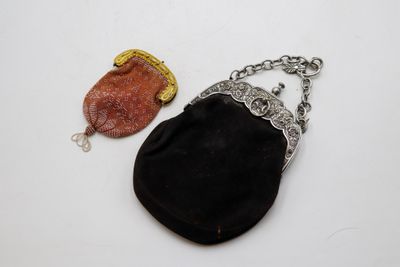 une image représentant un sac à main noir et un sac à main marron posés sur une surface blanche