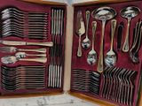 de nombreuses cuillères et fourchettes dans une boîte posée sur la table