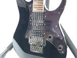 an image of a black electric guitar on a stand