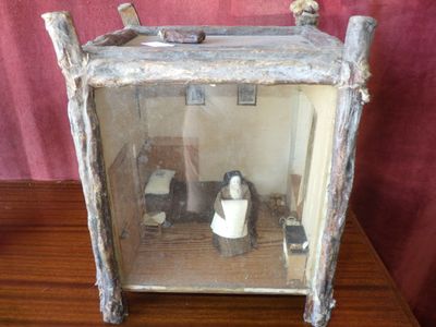 une petite boîte en bois contenant des toilettes et un distributeur de papier toilette