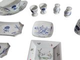 many different pieces of blue and white china on the table