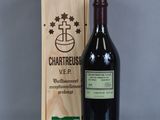 La bouteille de vin se trouve à côté de la boîte en bois sur la table.