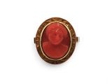 une bague en corail rouge et or ornée d'un visage de femme