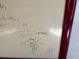 un tableau blanc sur lequel sont écrites des notes, entouré d'un cadre rouge
