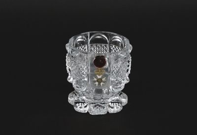 une image représentant un vase en verre orné d'une perle rouge
