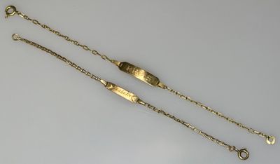 two gold bracelets on a white surface with a chain