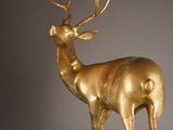 statue of a golden deer with antlers standing on a pedestal