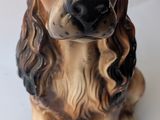 a figurine of a dog sitting on a white surface