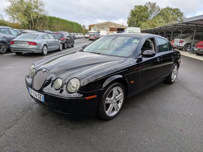the black jaguar is parked in a parking lot with other cars