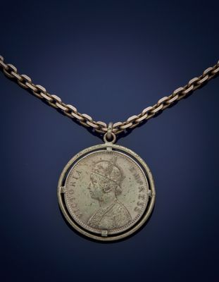 a silver coin with a chain around it on a blue background