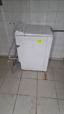 a small white refrigerator in the corner of a room