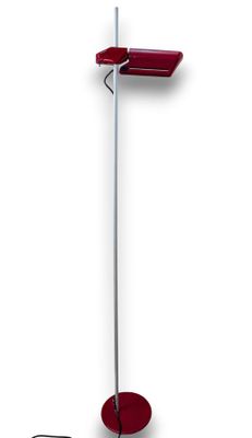 the floor lamp is red and has a metal pole with a red shade