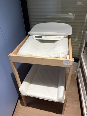 a small wooden shelf with towels on top of it
