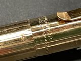 a close up of a gold colored pen with a black background