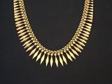 un collier en or orné de pointes sur fond noir