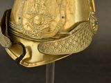 a gold helmet on a stand on a black background