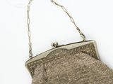 an old silver purse with a chain hanging from it ' s side