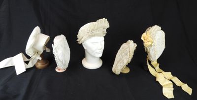 quatre chapeaux et un porte-chapeaux sur fond noir